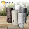 Several rain barrels of different colors are displayed on a tiled patio with greenery in the background. Produktbild-Vorschau