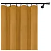 A close-up view of a mustard yellow curtain hanging from a black curtain rod. Náhled obrázku produktu