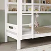 A close-up view of the lower section of a white bunk bed, showing the ladder, guardrail, and a shelf with books and a stuffed giraffe. Produktbild-Vorschau