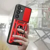 A hand holding a red and black phone case with a ring holder, with a blurred background of a room. Produktbild-Vorschau