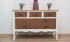 A dresser with a wood top and drawers with a rust-like pattern, decorated with two small potted plants and a vase. Náhľad obrázku produktu