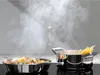 Steam rising from cooking pots on a stovetop, with icons indicating fan and Wi-Fi connectivity. Voir les images du produit