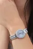 A woman's wrist wearing a silver watch. Produktbild-Vorschau