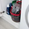 Cleaning supplies and a carpet cleaner are stored in a cabinet. Voir les images du produit