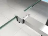 A close-up view of a metal support bracket connecting two glass panels, likely part of a shower enclosure. Produktbild-Vorschau