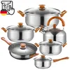 A collection of stainless steel cookware with wooden handles, arranged in a studio setting against a white background. Náhled obrázku produktu
