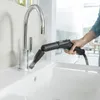 A person is using a steam cleaner attachment to clean a kitchen sink and faucet. Anteprima dell’immagine prodotto