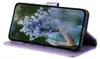 A purple flip case for a Samsung Galaxy S23 phone is shown standing upright, displaying a floral image on its screen. Produktbild-Vorschau
