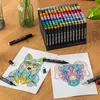 A set of alcohol markers is displayed on a wooden table, with two coloring pages and two markers in the foreground. Náhľad obrázku produktu