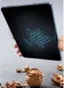 A hand holding a tablet with a hexagonal pattern on the screen, with walnuts and shells in the foreground. Anteprima dell’immagine prodotto
