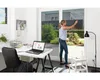 A woman is applying window tinting film to a large glass door in a home office setting. Podgląd zdjęcia produktu