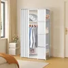 A white fabric wardrobe with a curtain, shown in a bedroom setting next to a window and a bedside table. Produktbild-Vorschau