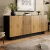 A modern sideboard with a geometric design is placed in a living room setting, next to a chair and a rug. Produktbild-Vorschau