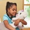 A young girl is holding a white plush dog with a pink bow on its head. Podgląd zdjęcia produktu