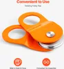 An orange pulley block with a rotating flap is shown against a white background. Text and icons highlight its features. Náhled obrázku produktu