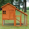 A wooden chicken coop with an attached run, set up on a grassy lawn with trees in the background. Produktbild-Vorschau