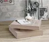 A coffee table in a living room setting with decorative items and artwork in the background. Náhľad obrázku produktu