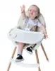 A baby sitting in a high chair. Produktbild-Vorschau