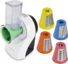 A white and black electric grater with a clear plastic food hopper and several colorful grating attachments. Náhľad obrázku produktu