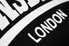 A close-up of text on a black fabric. Produktbild-Vorschau