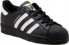 A studio shot of a black Adidas Superstar sneaker with white stripes and gold accents. Podgląd zdjęcia produktu