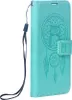 A teal colored book-style phone case with a dreamcatcher and owl embossed design, shown from the side. Náhled obrázku produktu