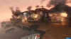 A burning dock with several buildings on fire, with smoke billowing into the sky during sunset. Produktbild-Vorschau