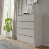 A modern, light gray chest of drawers with four drawers is shown in a well-lit room with sheer curtains and a potted plant. Produktbild-Vorschau