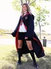 A woman dressed in a Gryffindor robe and tie stands in a grassy outdoor area, holding a wand. Produktbild-Vorschau