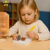 A young girl is focused on a needle felting project, creating a small bear figure. Produktbild-Vorschau