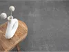 A white vase with decorative spheres on sticks sits on a rustic wooden stool, placed on a grey carpet. Produktbild-Vorschau