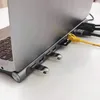 A close-up view of a laptop's side, showing a USB-C docking station with various ports and connected devices. Produktbild-Vorschau