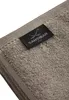 A close-up shot of a folded taupe towel with a black label attached. Produktbild-Vorschau