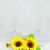 Two sunflowers are placed in front of a white embroidered curtain. Produktbild-Vorschau