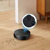 A black robot vacuum cleaner is cleaning up small dark particles on a light brown wooden floor. A magnified inset shows the underside of the robot with its wheels. Produktbild-Vorschau