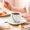 A person is having breakfast with a cup of tea and fruit on a wooden table. Náhled obrázku produktu