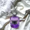 A purple perfume bottle with a silver ornate cap and a pearl accent, placed on a white, textured fabric. Náhľad obrázku produktu