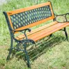 A wooden and metal garden bench sits on grass. Podgląd zdjęcia produktu