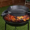 A cast iron skillet is placed on a grill over glowing coals. Produktbild-Vorschau