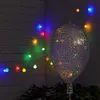 A string of colorful lights is draped across a wooden wall, with a large, spherical disco ball-like light fixture in the foreground. Produktbild-Vorschau