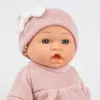 Close-up of a baby doll wearing a pink knitted outfit and hat. Produktbild-Vorschau