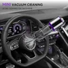 A mini vacuum cleaner is being used to clean the interior of a car, specifically near the steering wheel. Produktbild-Vorschau