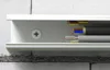 Close-up view of electrical and coaxial cables inside a white cable management channel mounted on a brick wall. Voir les images du produit