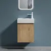 A modern bathroom vanity with a white sink and a wood-grain cabinet mounted on a blue wall. Produktbild-Vorschau