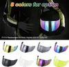 A person wearing a motorcycle jacket and gloves holds a motorcycle helmet with a colorful visor. Below are multiple motorcycle helmet visors in different colors. Podgląd zdjęcia produktu