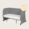 A gray baby bed with a white mattress and a weight limit icon. Náhľad obrázku produktu