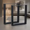Two black metal table legs are shown in a modern living room setting. Náhled obrázku produktu