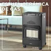A gas heater is shown in a living room setting with a sofa in the background. Podgląd zdjęcia produktu