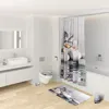 A clean, modern bathroom with a toilet, sink, shower curtain, and bath mat, all featuring a butterfly and stone motif. Produktbild-Vorschau