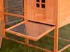 A close-up view of a wooden chicken coop with a pull-out tray extended. Produktbild-Vorschau
